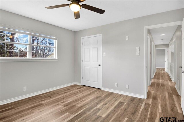 unfurnished bedroom with ceiling fan and wood-type flooring