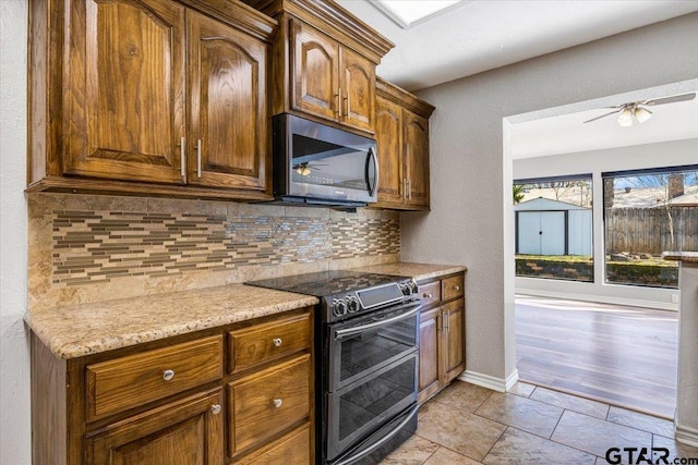 kitchen with ceiling fan, electric range oven, light stone countertops, and tasteful backsplash