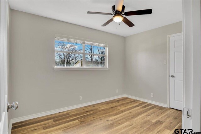 empty room with ceiling fan and light hardwood / wood-style floors