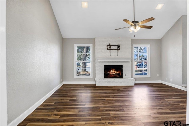 unfurnished living room with dark hardwood / wood-style flooring, ceiling fan, a fireplace, and vaulted ceiling