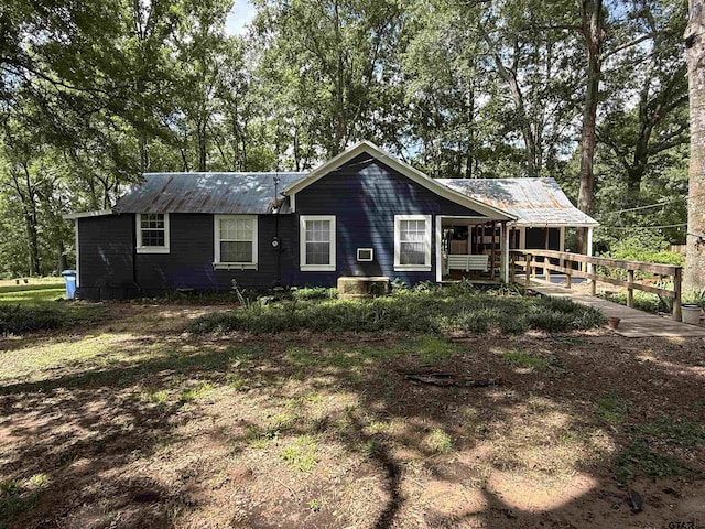 2595 Fm 1857 S, Rusk, TX 75785 - back of house with a metal roof, view of wooded area, and covered porch