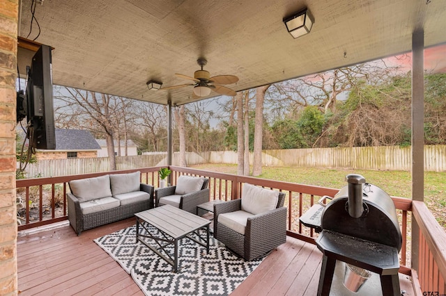 wooden terrace featuring outdoor lounge area, a fenced backyard, a ceiling fan, and a grill