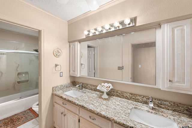 bathroom featuring crown molding, shower / bath combination with glass door, a sink, and double vanity