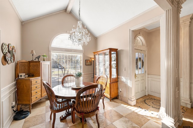 dining area with a wainscoted wall, a notable chandelier, a decorative wall, lofted ceiling with beams, and ornamental molding