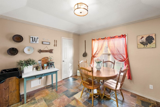 dining space with ornamental molding, stone tile flooring, and baseboards