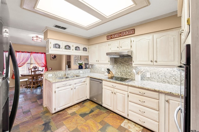 kitchen featuring a skylight, visible vents, under cabinet range hood, black appliances, and a sink