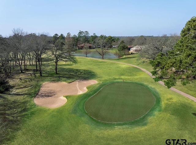 surrounding community featuring a water view, view of golf course, and a yard