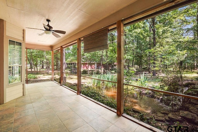 unfurnished sunroom featuring a ceiling fan