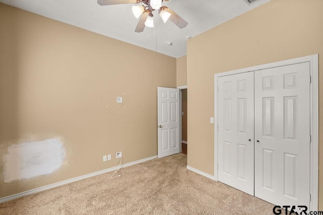 unfurnished bedroom featuring baseboards, carpet flooring, a closet, and ceiling fan