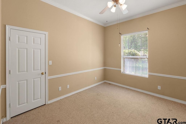 empty room with ceiling fan, baseboards, ornamental molding, and carpet flooring