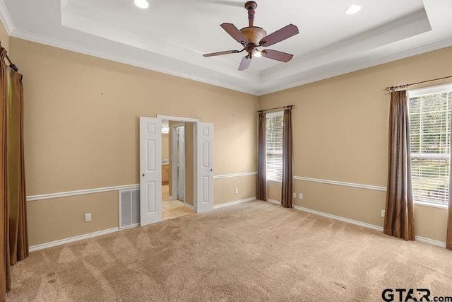 unfurnished bedroom featuring light carpet, a raised ceiling, ornamental molding, visible vents, and recessed lighting
