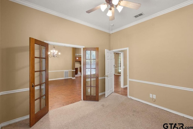 carpeted empty room with visible vents, crown molding, baseboards, and french doors