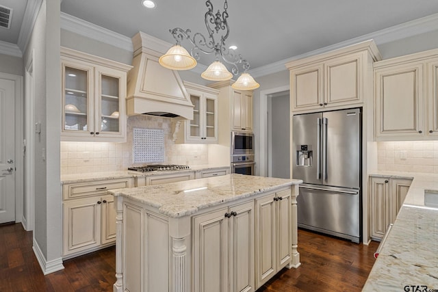 kitchen with dark wood-type flooring, cream cabinetry, a center island, and stainless steel appliances