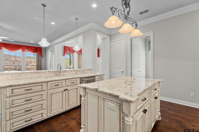 kitchen featuring dark wood-style flooring, a sink, visible vents, and cream cabinetry