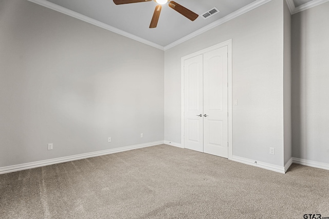 unfurnished bedroom featuring crown molding, carpet, a closet, visible vents, and baseboards