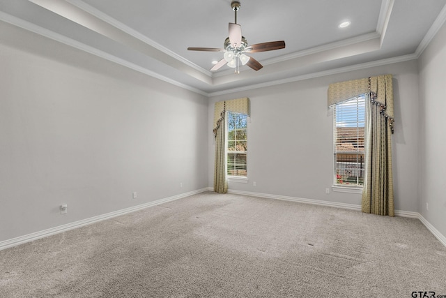carpeted empty room featuring a tray ceiling, ceiling fan, baseboards, and plenty of natural light
