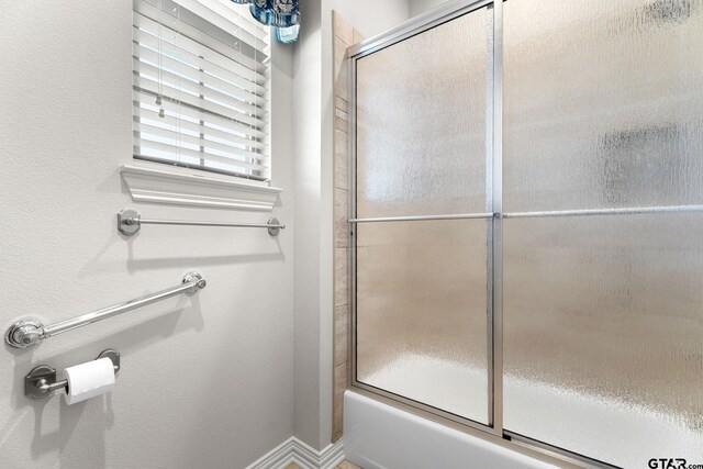 full bath featuring baseboards and enclosed tub / shower combo