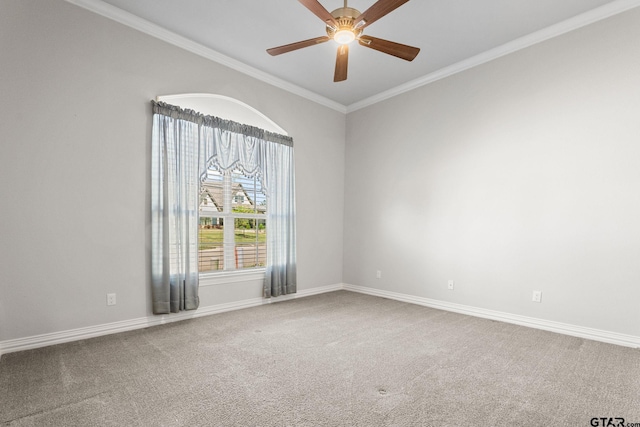 carpeted spare room with baseboards, a ceiling fan, and crown molding