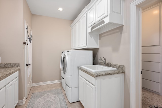 clothes washing area with sink, light tile patterned floors, cabinets, and independent washer and dryer