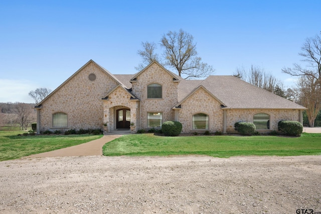 french provincial home featuring a front yard