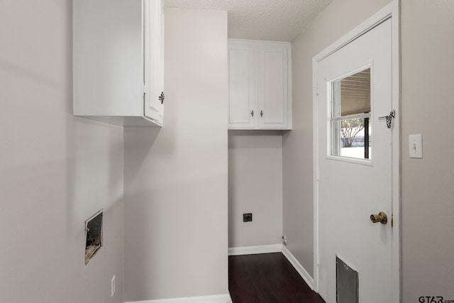 laundry area with cabinets, hookup for an electric dryer, hookup for a washing machine, a textured ceiling, and hardwood / wood-style flooring