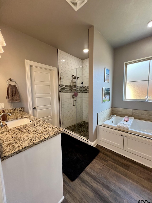 bathroom with vanity, separate shower and tub, and hardwood / wood-style floors