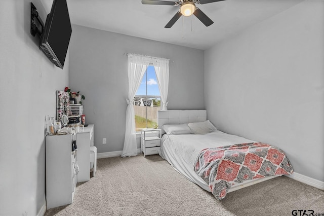 bedroom with baseboards, a ceiling fan, and light colored carpet