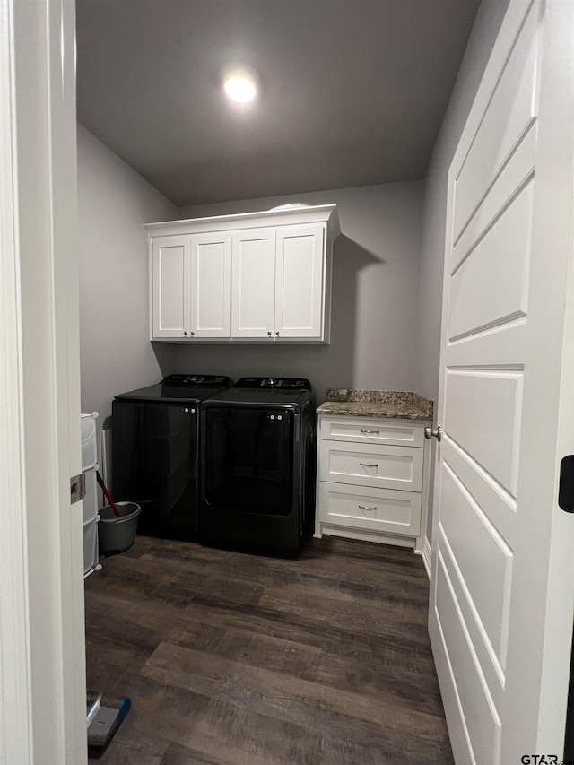 laundry area with cabinet space, dark wood-style flooring, and washing machine and clothes dryer