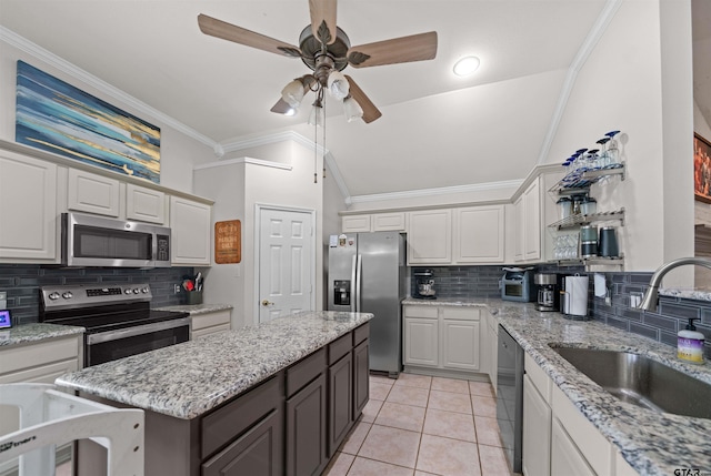 7032 La Hacienda Dr, Flint, TX 75762 - kitchen featuring appliances with stainless steel finishes, a sink, a ceiling fan, decorative backsplash, and ornamental molding