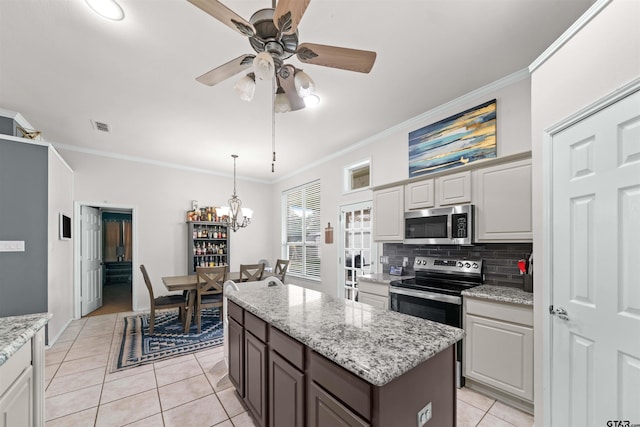 7032 La Hacienda Dr, Flint, TX 75762 - kitchen featuring stainless steel appliances, crown molding, light tile patterned floors, tasteful backsplash, and a ceiling fan