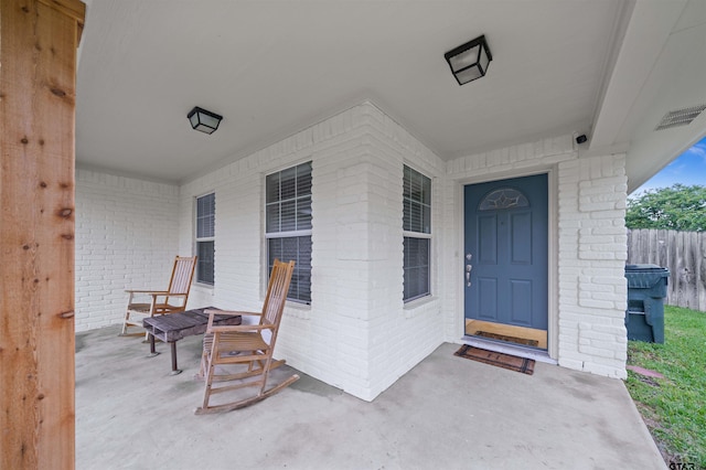 7032 La Hacienda Dr, Flint, TX 75762 - view of exterior entry featuring a porch, brick siding, and fence