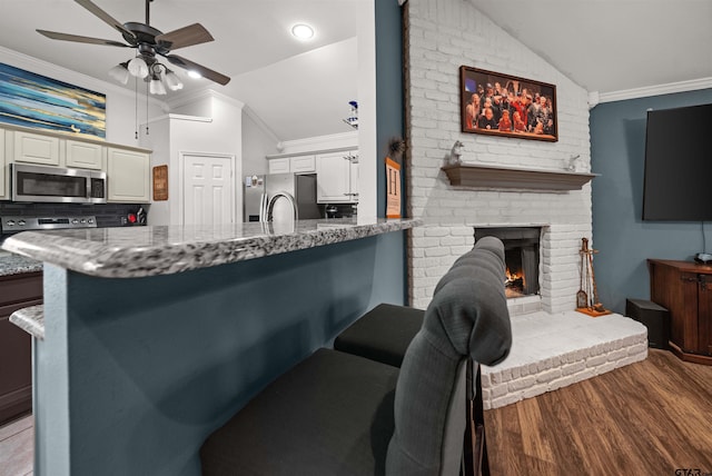 7032 La Hacienda Dr, Flint, TX 75762 - kitchen with appliances with stainless steel finishes, vaulted ceiling, a ceiling fan, ornamental molding, and light stone counters