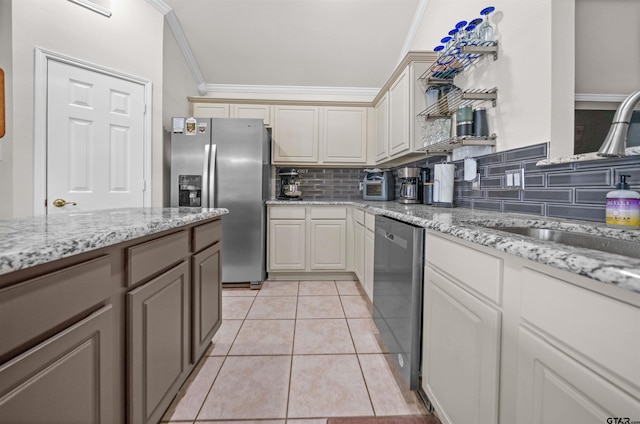 7032 La Hacienda Dr, Flint, TX 75762 - kitchen with stainless steel appliances, decorative backsplash, a sink, ornamental molding, and light tile patterned floors