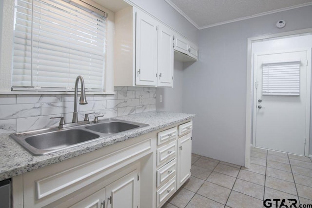 12595 Oneall St, Tyler, TX 75704 - kitchen with a sink, crown molding, white cabinetry, light countertops, and light tile patterned floors