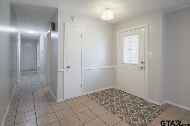 12595 Oneall St, Tyler, TX 75704 - foyer entrance featuring light tile patterned floors, baseboards, and a textured ceiling