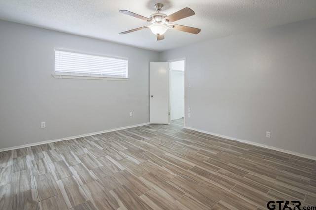 12595 Oneall St, Tyler, TX 75704 - spare room with light wood-style flooring, a ceiling fan, baseboards, and a textured ceiling