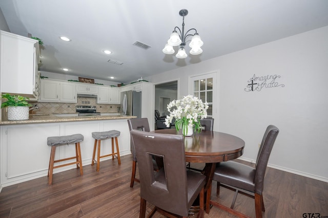 dining room featuring dark hardwood / wood-style flooring, sink, and a notable chandelier