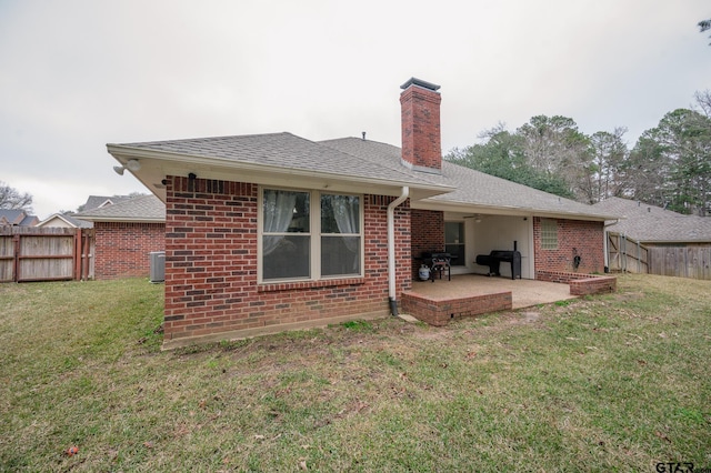 rear view of property featuring central AC, a lawn, and a patio