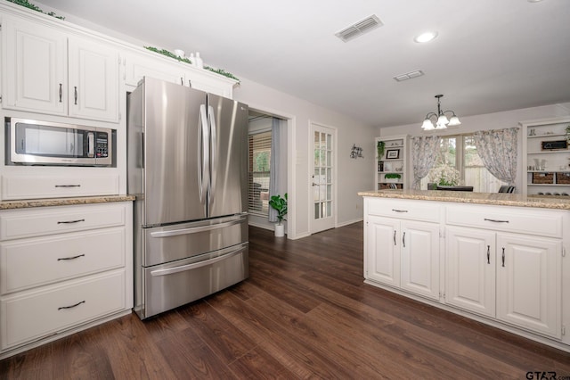 kitchen with pendant lighting, appliances with stainless steel finishes, dark hardwood / wood-style flooring, and white cabinets