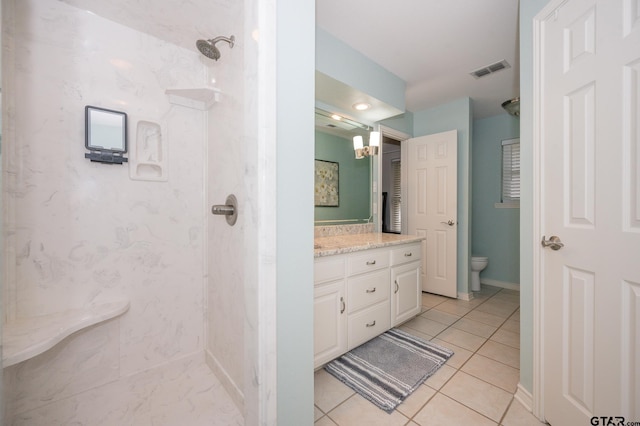 bathroom featuring walk in shower, vanity, tile patterned floors, and toilet