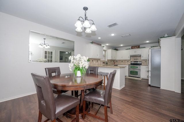 dining area featuring dark wood-type flooring and a notable chandelier