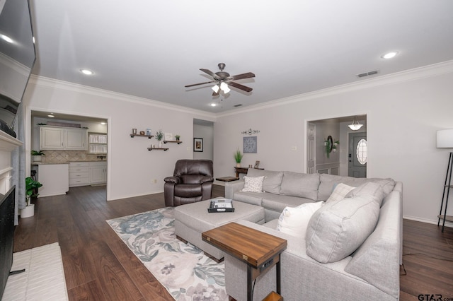 living room featuring dark hardwood / wood-style flooring, a brick fireplace, crown molding, and ceiling fan