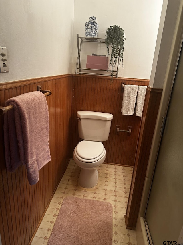 bathroom featuring walk in shower, wood walls, and toilet