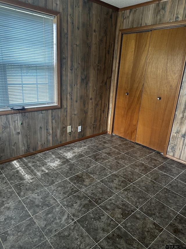 unfurnished bedroom featuring wood walls and a closet