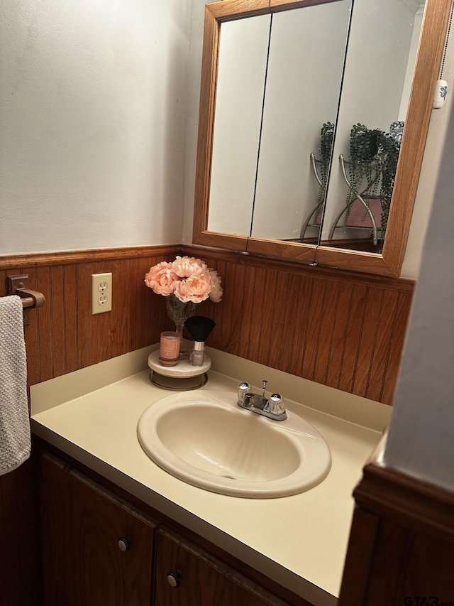 bathroom featuring wood walls and vanity