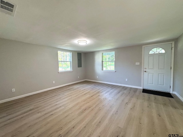 foyer featuring electric panel, plenty of natural light, and light hardwood / wood-style floors