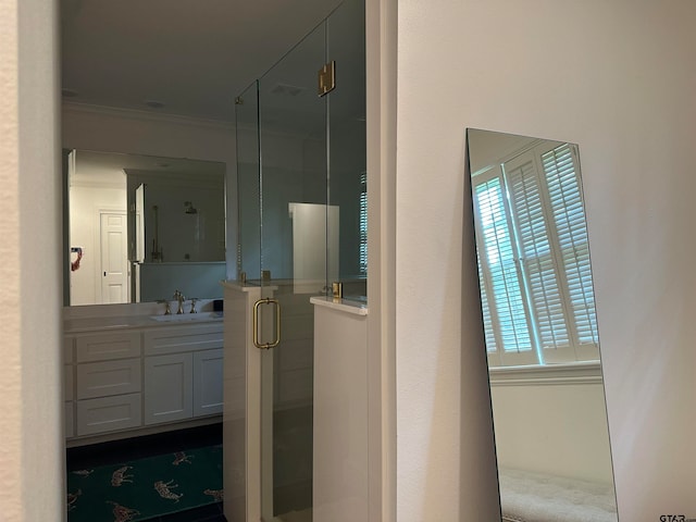 bathroom with walk in shower, vanity, and ornamental molding