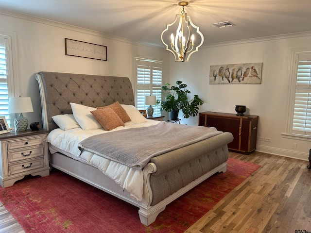 bedroom with dark wood-type flooring, a chandelier, and crown molding