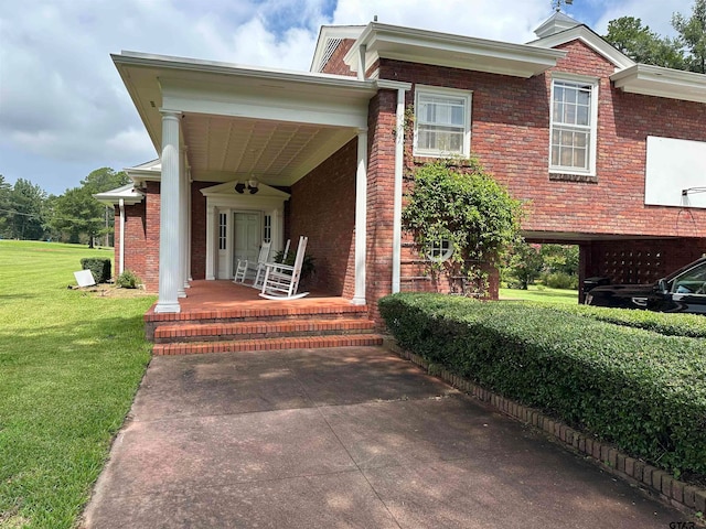 view of front of property featuring covered porch, ceiling fan, and a front lawn