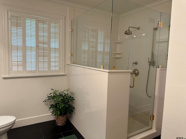 bathroom with toilet, tile patterned floors, crown molding, and a shower with door